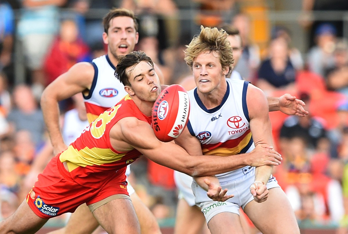 Crows player Rory Sloane (right) gets the ball away during a tackle during the round 9 AFL match between the Gold Coast Suns and the Adelaide Crows at Metricon Stadium on the Gold Coast, Saturday, May 21, 2016. (AAP Image/Dave Hunt) NO ARCHIVING, EDITORIAL USE ONLY