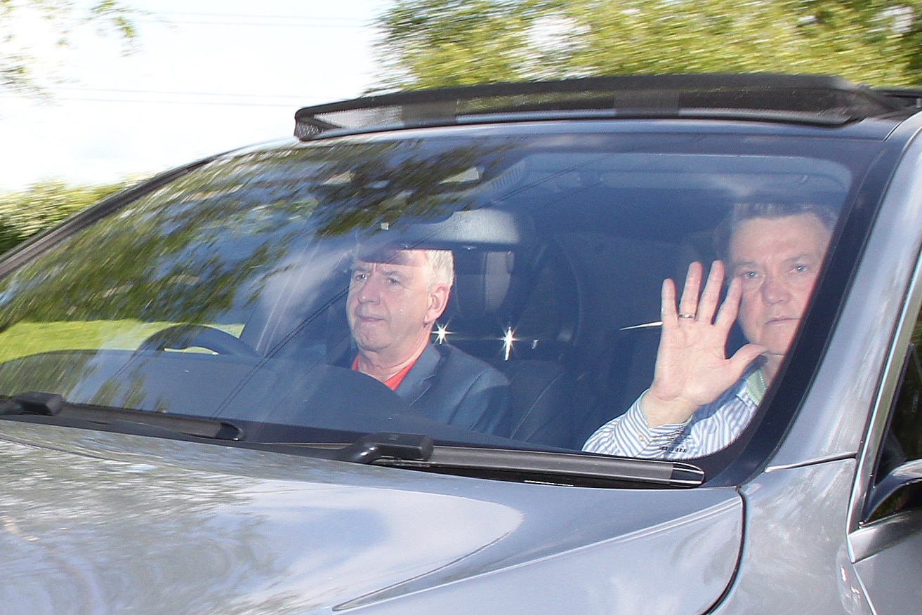 Louis van Gaal waves goodbye as he is driven out of Carrington, near Manchester United's Trafford Training Ground, on Monday afternoon, UK time.