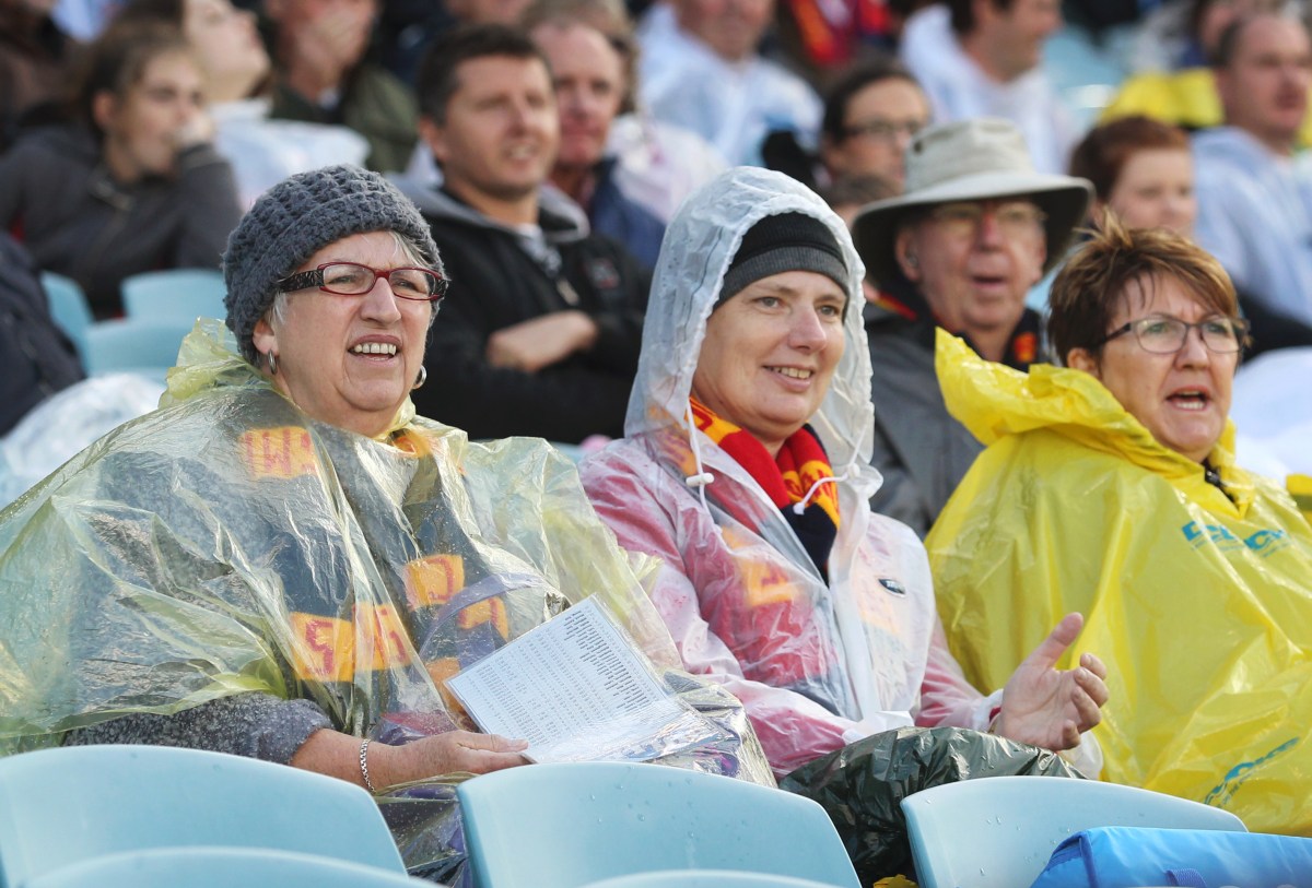 Adelaide Crows fans brave the elements after the heavy rain fell during the round four AFL match between Adelaide and Western Bulldogs at AAMI Stadium in Adelaide, Sunday, April 21, 2013. (AAP Image/Ben Macmahon) NO ARCHIVING, EDITORIAL USE ONLY