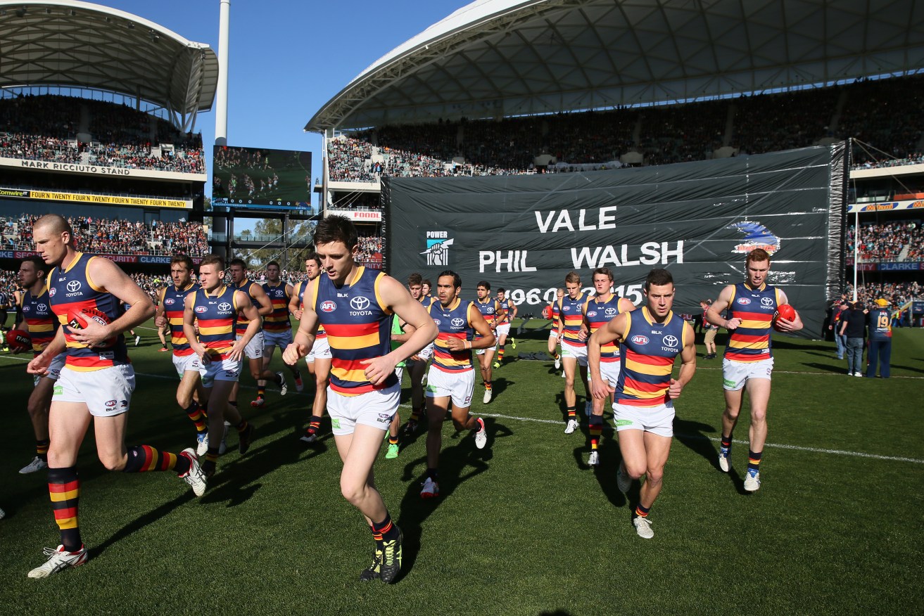 Crows and Port Adelaide players ran through the same banner as a tribute to Phil Walsh before last year's Showdown. Photo: Ben Macmahon, AAP.