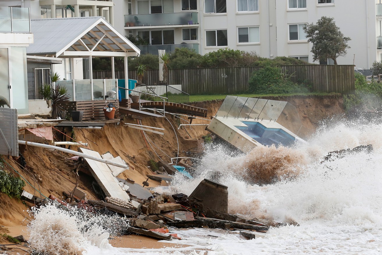 Waves crash against a  swimming pool that was washed away from a property at Collaroy in Sydney's Northern Beaches. Photo: AAP/David Moir
