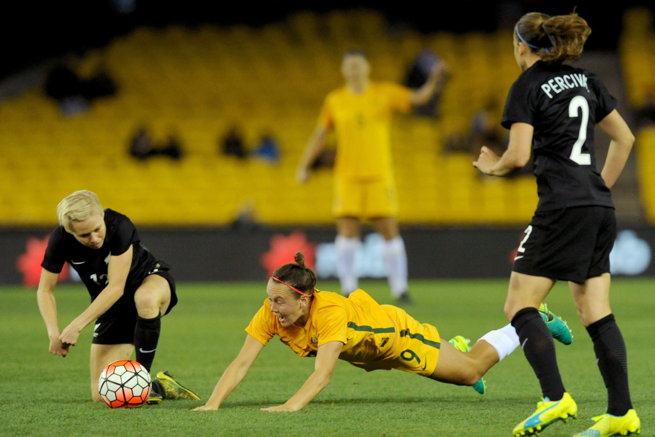 Caitlin Foord of the Matildas loses control of the ball against Betsy Hassett of New Zealand. Photo: Joe Castro, AAP.