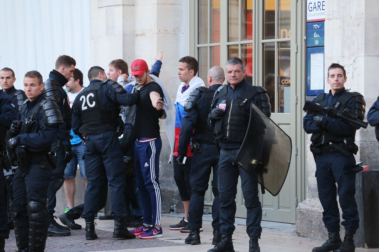 Russian fans are searched by French police outside the train station in Lille city centre. Photo: Niall Carson, PA Wire.