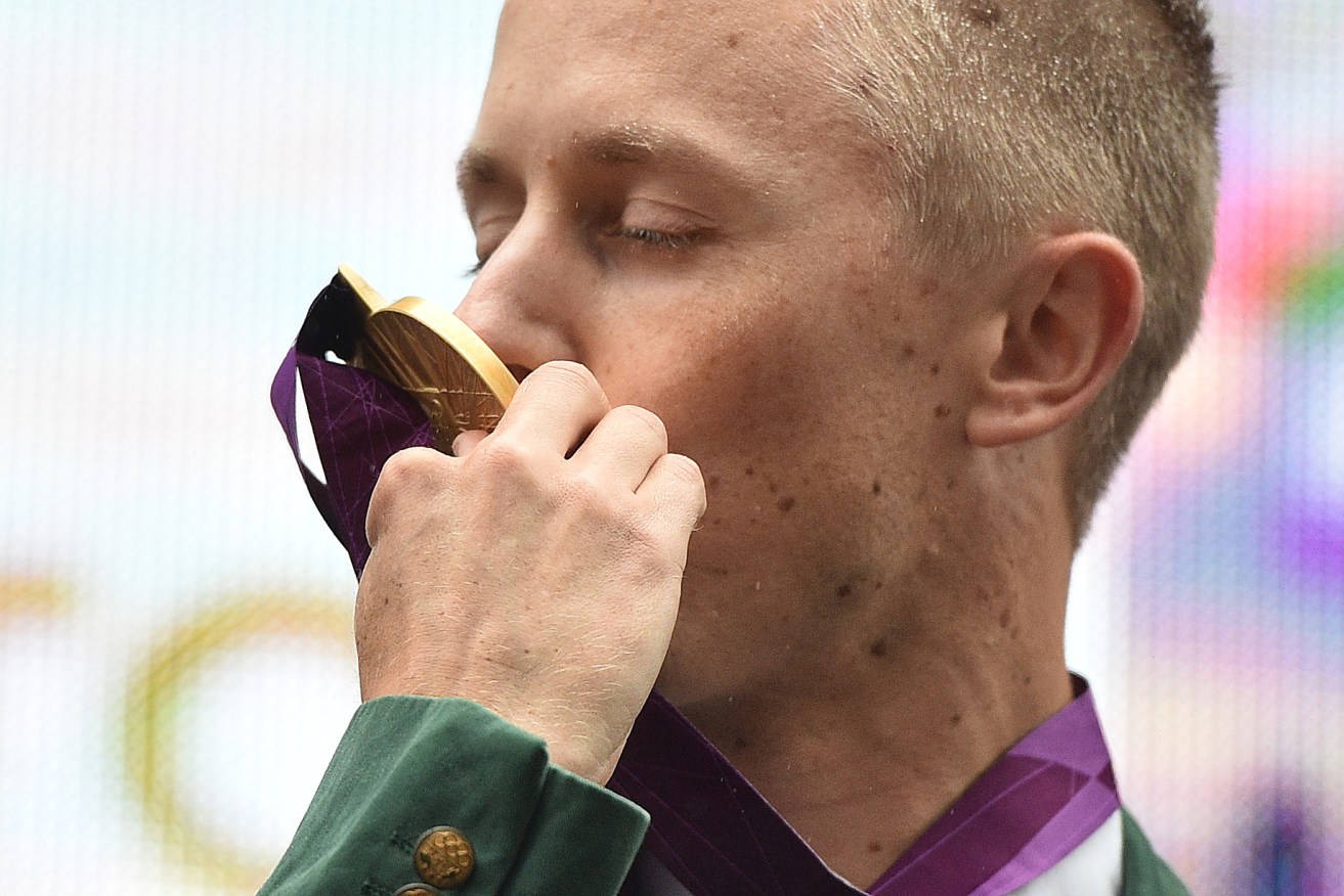 Jared Tallent kisses his belatedly presented gold medal for the 50km walk at the 2012 London Olympics on the steps of the Treasury in Melbourne. Photo: Julian Smith, AAP.