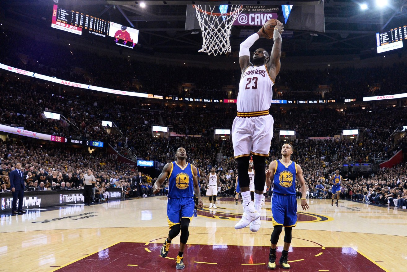 Cleveland Cavaliers forward LeBron James dunks as Golden State Warriors guard Stephen Curry and forward Andre Iguodala look on during game six. Photo: LARRY W. SMITH CORBIS OUT, EPA.