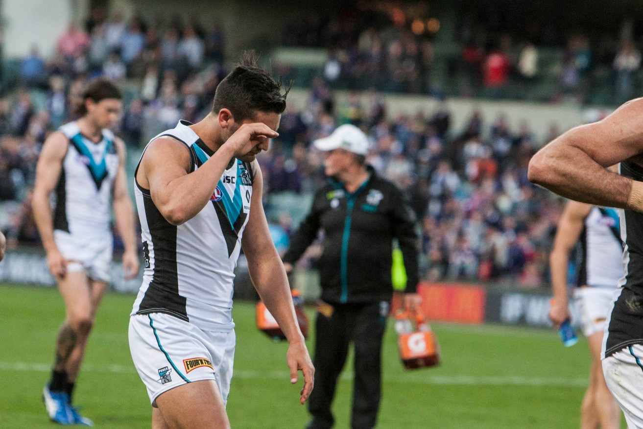 Chad Wingard leaves the field after a loss in his 100th game. Photo: Tony McDonough, AAP.