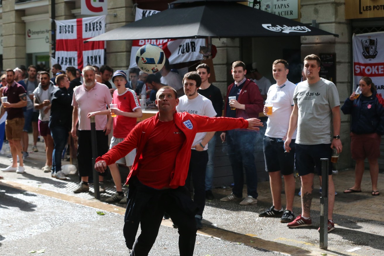 England fans play football outside a bar in Place Jean Jaures, Saint-Etienne. Photo: Niall Carson, PA Wire.