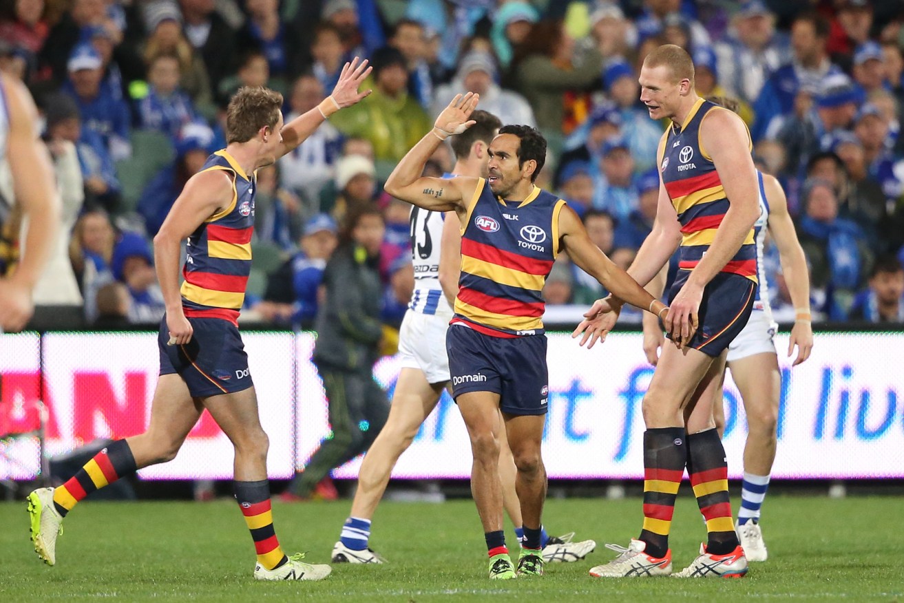 Eddie Betts is congratulated by teammates Matt Crouch and Sam Jacobs after kicking a goal during the Crows' win over the Kangaroos. Photo: Ben Macmahon, AAP.