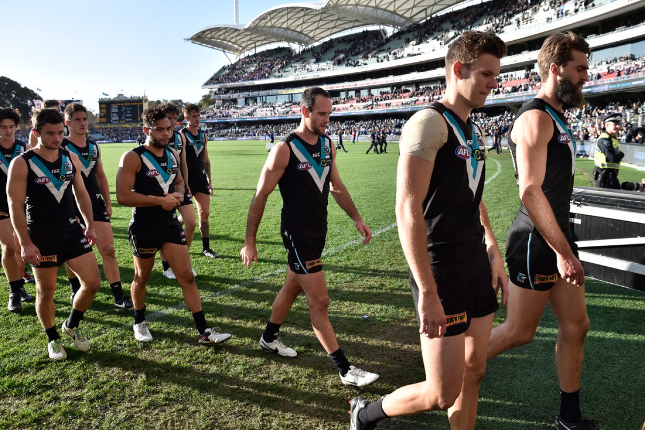 Dejected Port Adelaide players after the Round 12 AFL match some fans were unable to attend because of public transport issues. AAP Image/David Mariuz