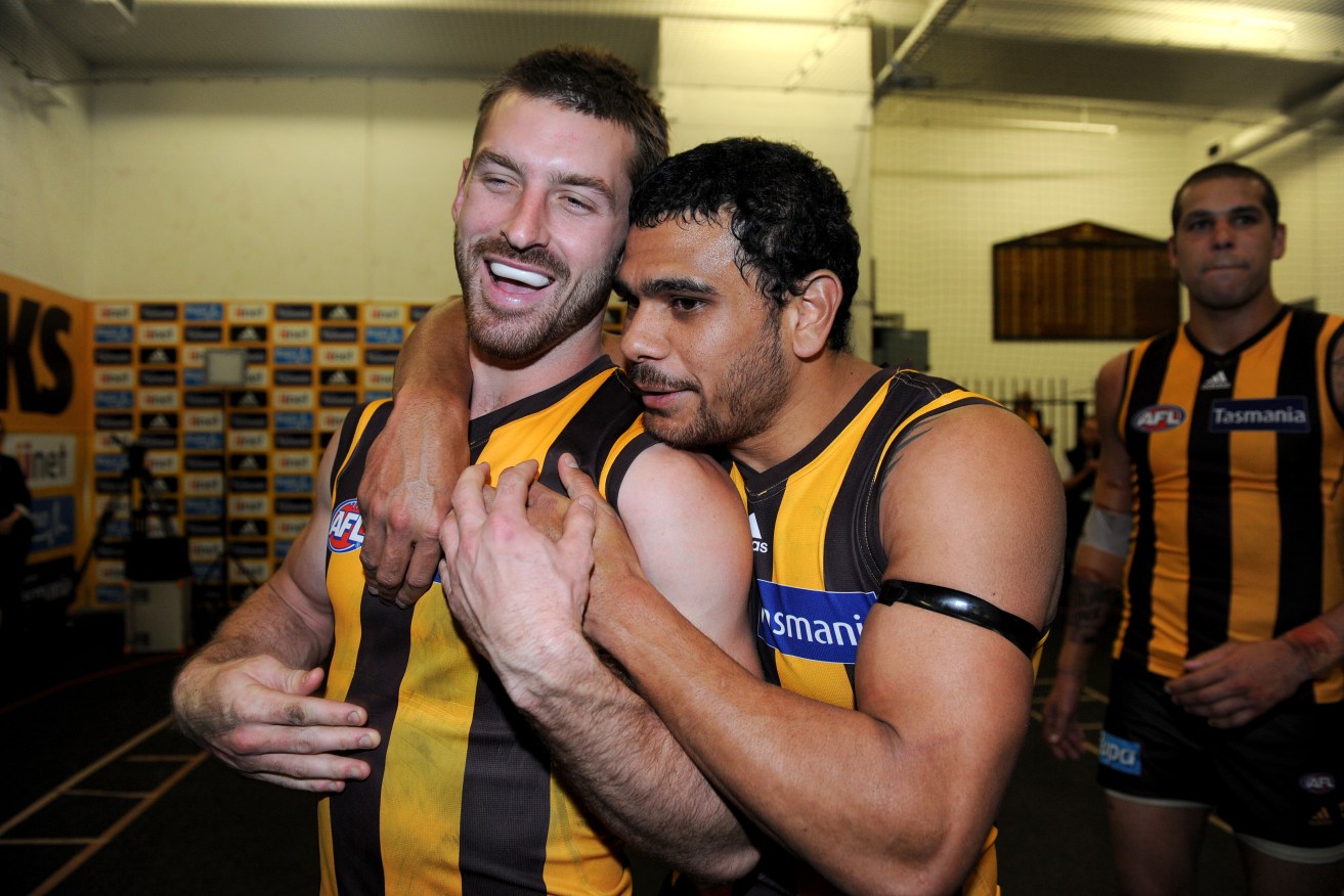 Brendan Whitecross celebrates with Cyril Rioli after their nailbiting win over Geelong in the 2013 preliminary final - in which he ruptured his ACL for the second time. Photo: Joe Castro, AAP.