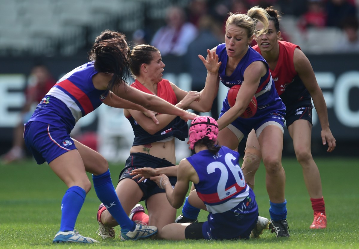 Melbourne Demons player Chelsea Randall (second from left) is tackled as they play the Western Bulldogs during their WAFL game at the MCG in Melbourne, Sunday, May 24, 2015. (AAP Image/Julian Smith) NO ARCHIVING, EDITORIAL USE ONLY