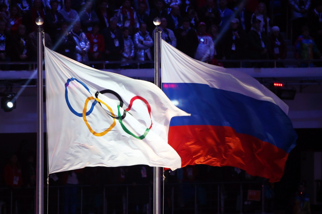 The Russian flag flies next to the Olympic rings at the closing ceremony of the Sochi games in 2014. Photo: HANNIBAL HANSCHKE, EPA. 