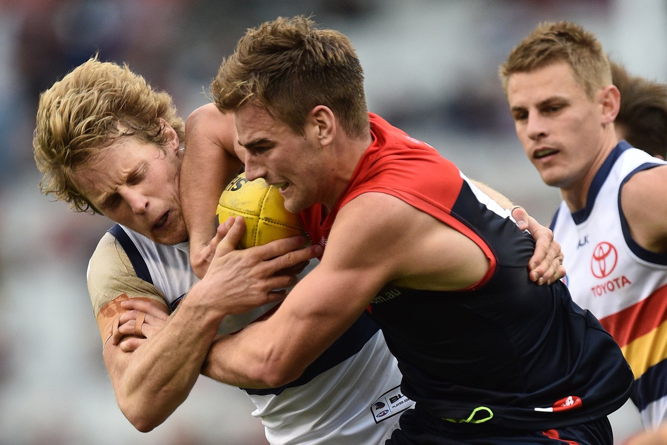 Rory Sloane lays a tackle on Demon Dom Tyson. Photo: Julian Smith, AAP.