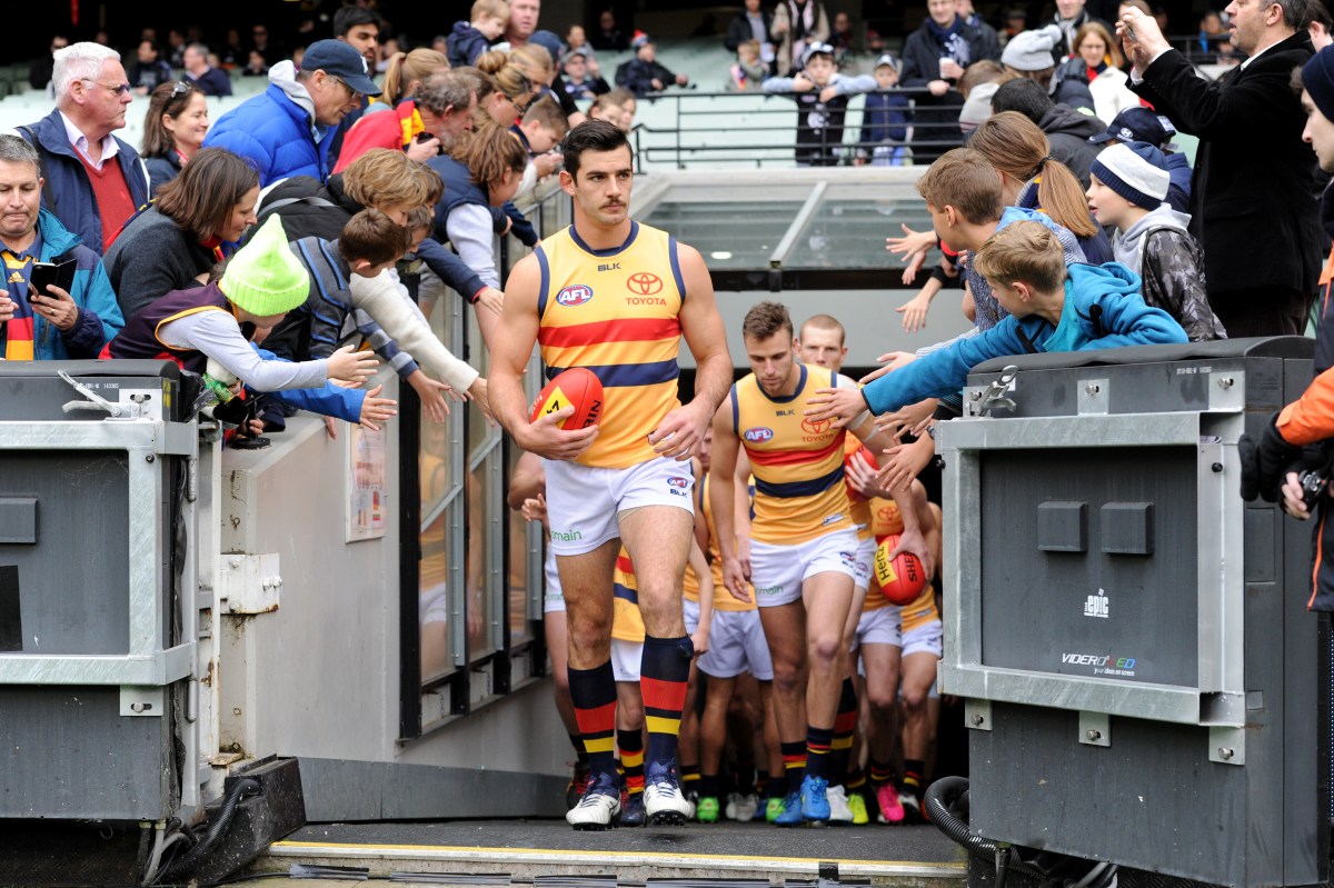 Taylor Walker of the Crows leads his side onto the ground, during the AFL Round 16 between the Carlton Blues and Adelaide Crows, played at the MCG in Melbourne, Sunday, July 10, 2016. (AAP Image/Joe Castro) NO ARCHIVING, EDITORIAL USE ONLY