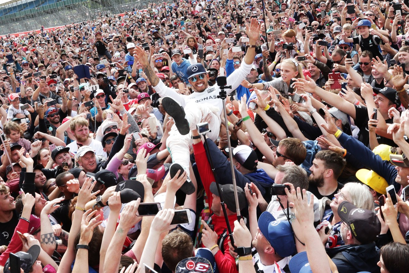 Race winner Lewis Hamilton celebrates with the fans.