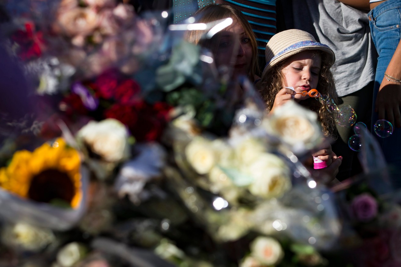 A child blows bubbles as people gather in front of a memorial on the 'Promenade des Anglais' where the Bastille Day atrocity occurred. Photo: EPA