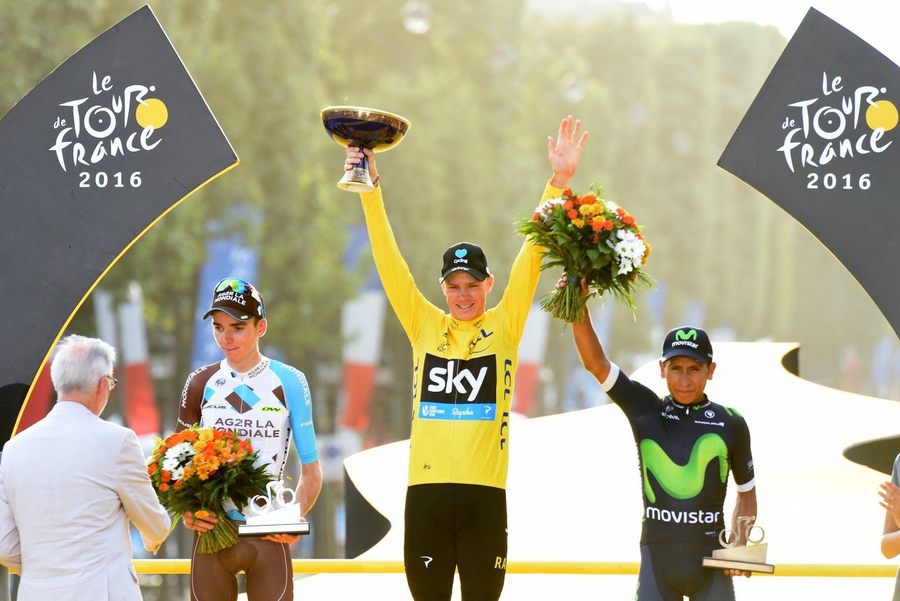 Team Sky's Chris Froome celebrates as he collects the yellow jersey for winning the Tour De France, alongside second place Romain Bardet (left) and third place Nairo Quintana (right).