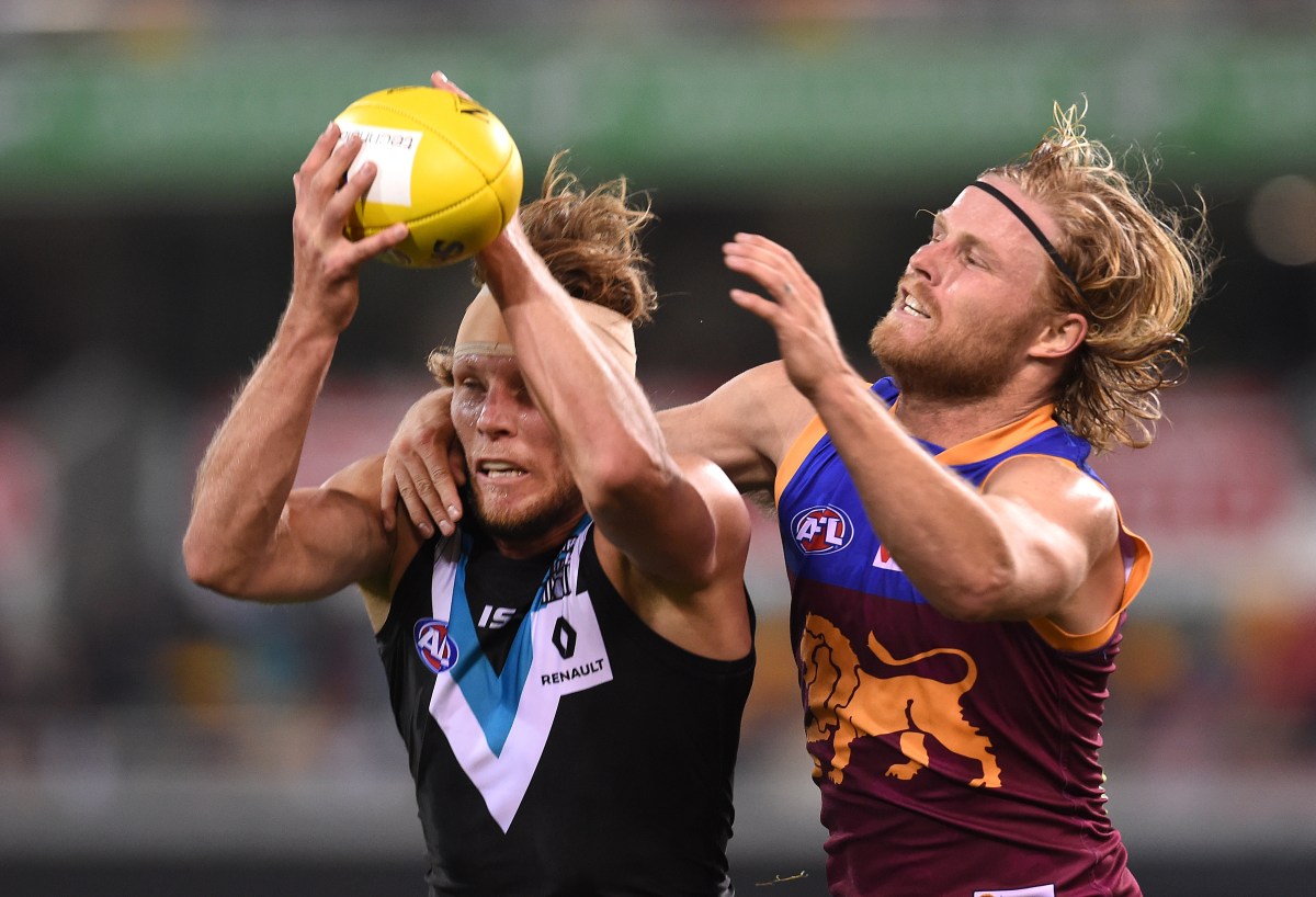 Brad Ebert of the Port Adelaide Power (left) takes a mark ahead of Daniel Rich of the Brisbane Lions during their round 19 AFL game at the Gabba in Brisbane, Saturday, July 30, 2016. (AAP Image/Dan Peled) NO ARCHIVING, EDITORIAL USE ONLY