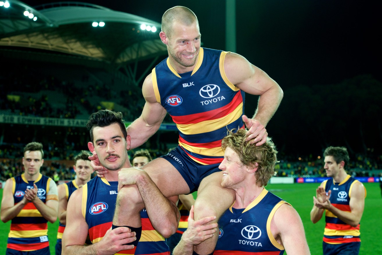 Scott Thompson is chaired off the ground after his 300th game. Photo: Michael Errey / InDaily