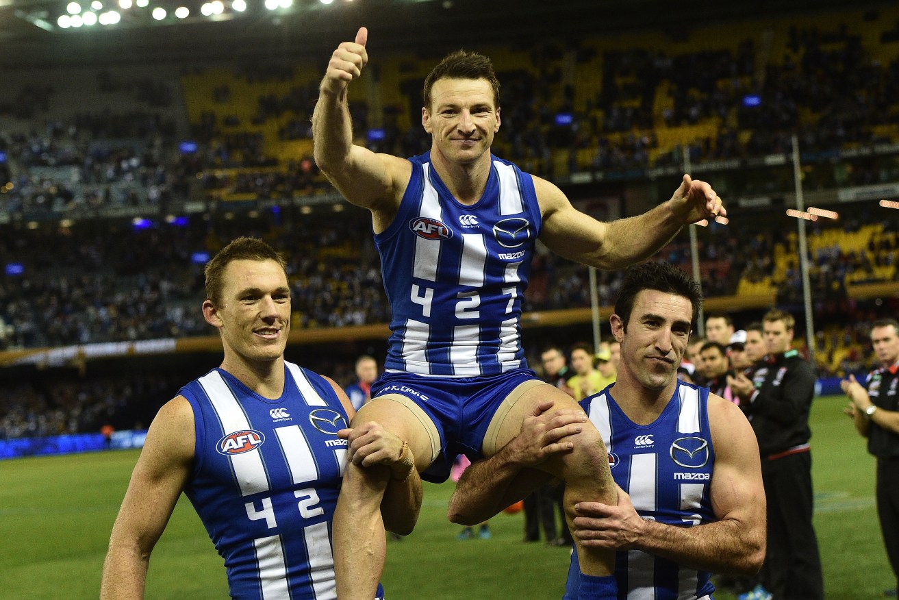 Brent Harvey is chaired from the ground by Drew Petrie and Michael Firrito after breaking the AFL games record. All three, as well as Nick Dal Santo, have been told their time is up at North Melbourne. Photo: Julian Smith / AAP