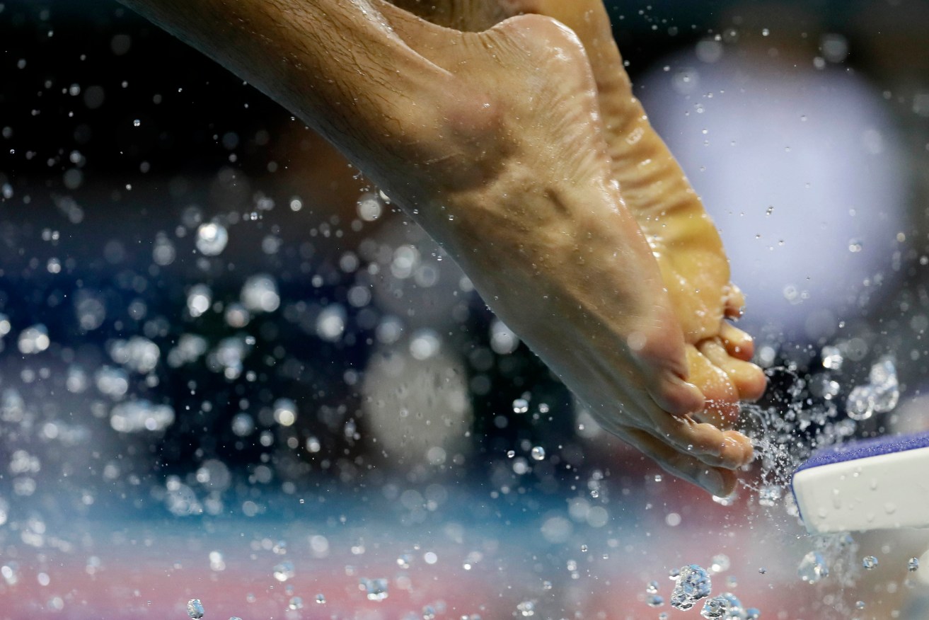 A swimmer enters the pool during a training session ahead of the Olympics. Photo: Matt Slocum, AP.