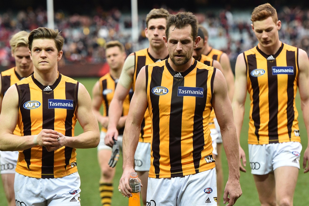 Luke Hodge leads his teammates from the field after an unexpected loss to the Demons. Photo: Julian Smith, AAP.