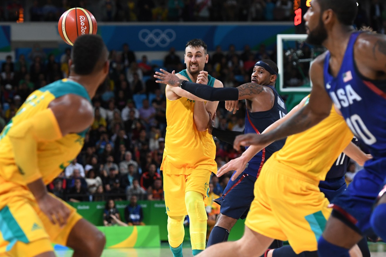 Andrew Bogut gets a pass away despite the efforts of Carmelo Anthony. Photo: Dean Lewins, AAP.