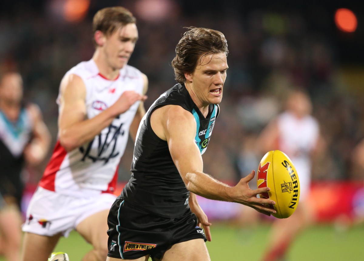Jared Polec of the Power gets hand to ball in front of Oscar McDonald of the Demons during the Round 21 AFL match between the Port Adelaide Power and the Melbourne Demons at Adelaide Oval in Adelaide, Saturday, Aug. 13, 2016. (AAP Image/Ben Macmahon) NO ARCHIVING, EDITORIAL USE ONLY