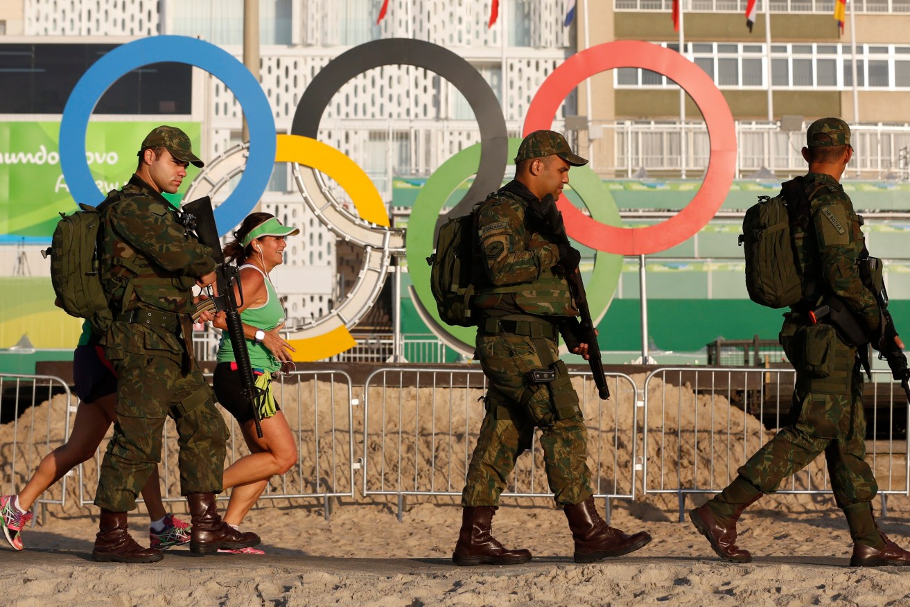Special military police patrol Copacabana Beach next to morning joggers. Photo: BARBARA WALTON / EPA.