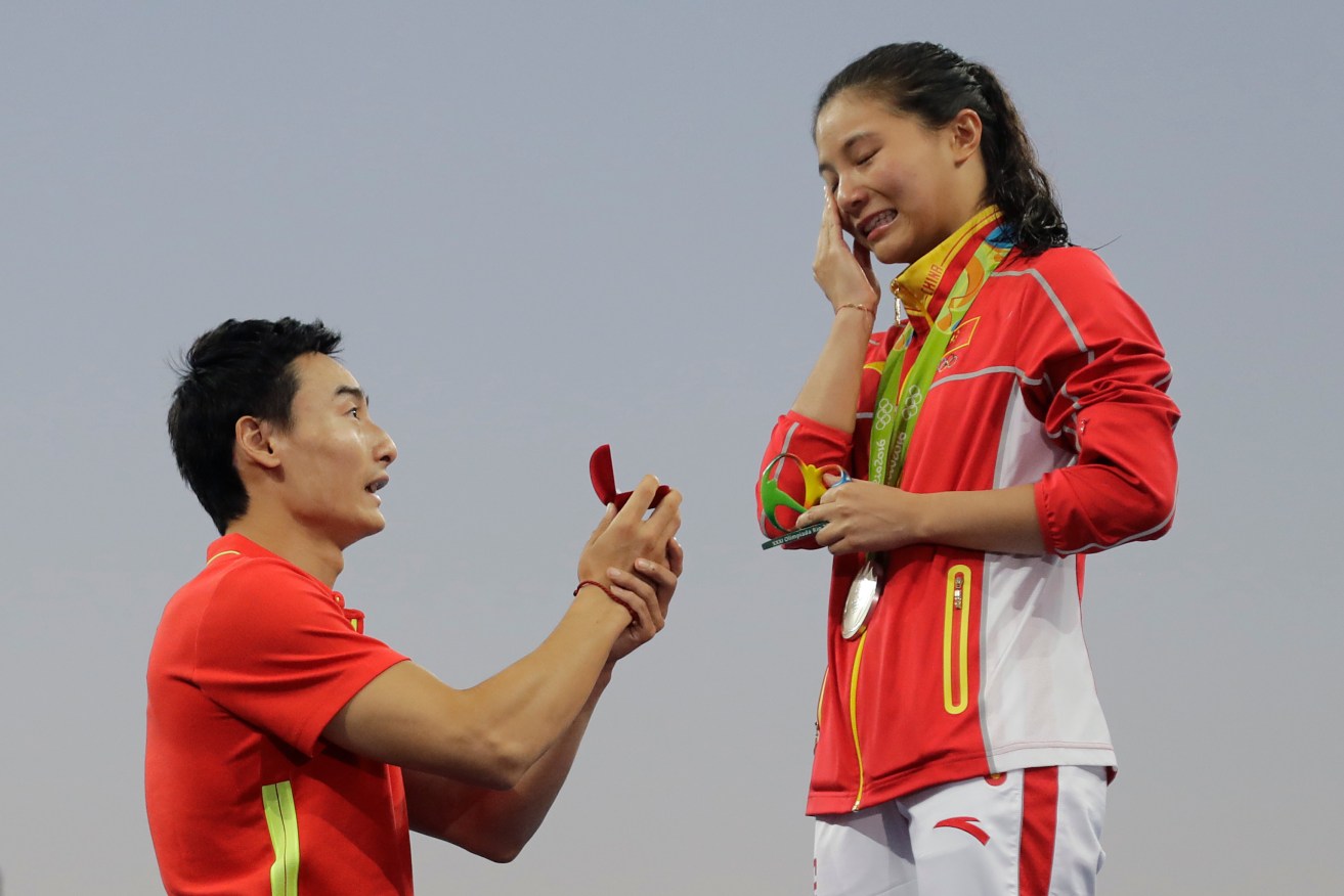 China's diver Qin Kai, left, proposes to silver medalist He Zhi after the women's 3-metre springboard diving finals. Photo: Wong Maye-E, AP.