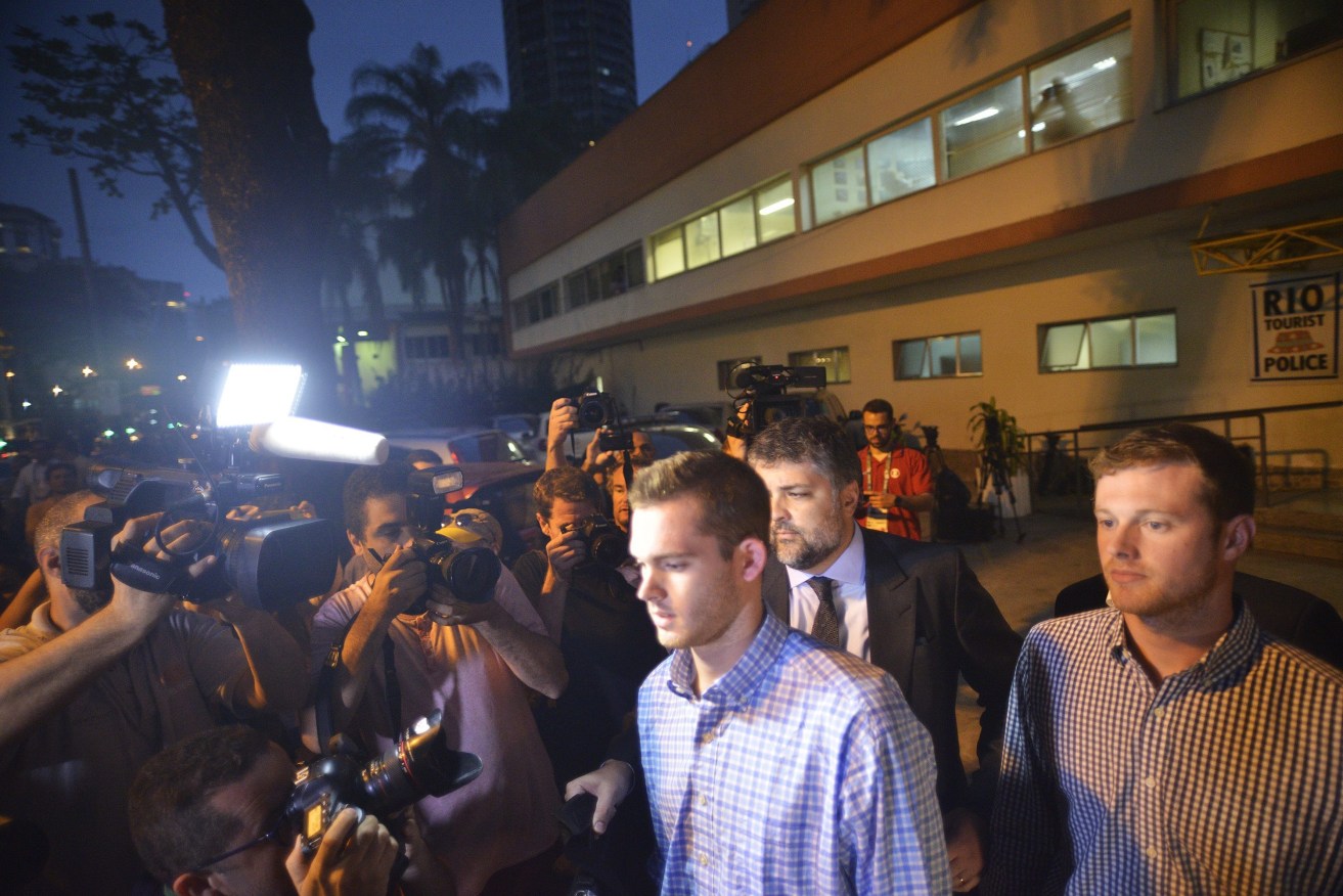 US Olympic swimmers Jack Conger (right) and Gunnar Bentz (centre) after being questioned by the Special Police Station of Tourists Attention in Rio. Brazilian police say Ryan Lochte and three of his compatriots, including Conger and Bentz, made up the story about a robbery at gunpoint in the city to cover for their alleged vandalism at a petrol station. Photo: FABIO TEIXEIRA / EPA.