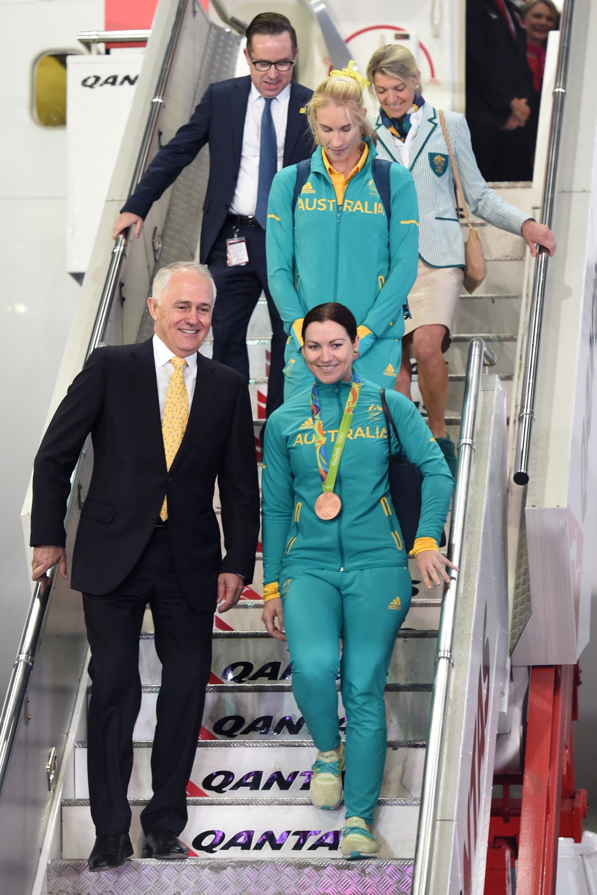 Australian Olympic team members Anna Mears (right), Kim Brennan (centre) and chef de mission Kitty Chiller are welcomed home by Australian Prime Minister Malcolm Turnbull (left), and Qantas CEO Alan Joyce, from Rio de Janeiro on their return from the XXXI Summer Olympics, in Sydney on Wednesday, Aug. 24, 2016. (AAP Image/Paul Miller) NO ARCHIVING