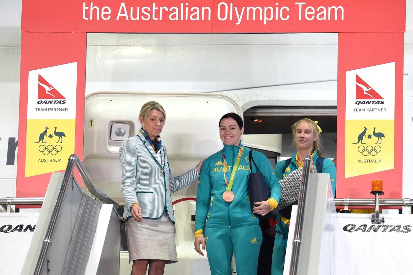 Chef de mission Kitty Chiller joins flag bearer Anna Meares and Australian teammate Kim Brennan alighting the plane from Rio today. Photo: Paul Miller / AAP
