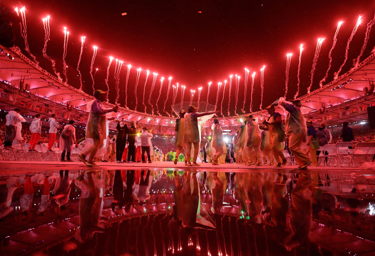Dancers and fireworks are reflected in a puddle in the Maracana stadium. Photo: PA