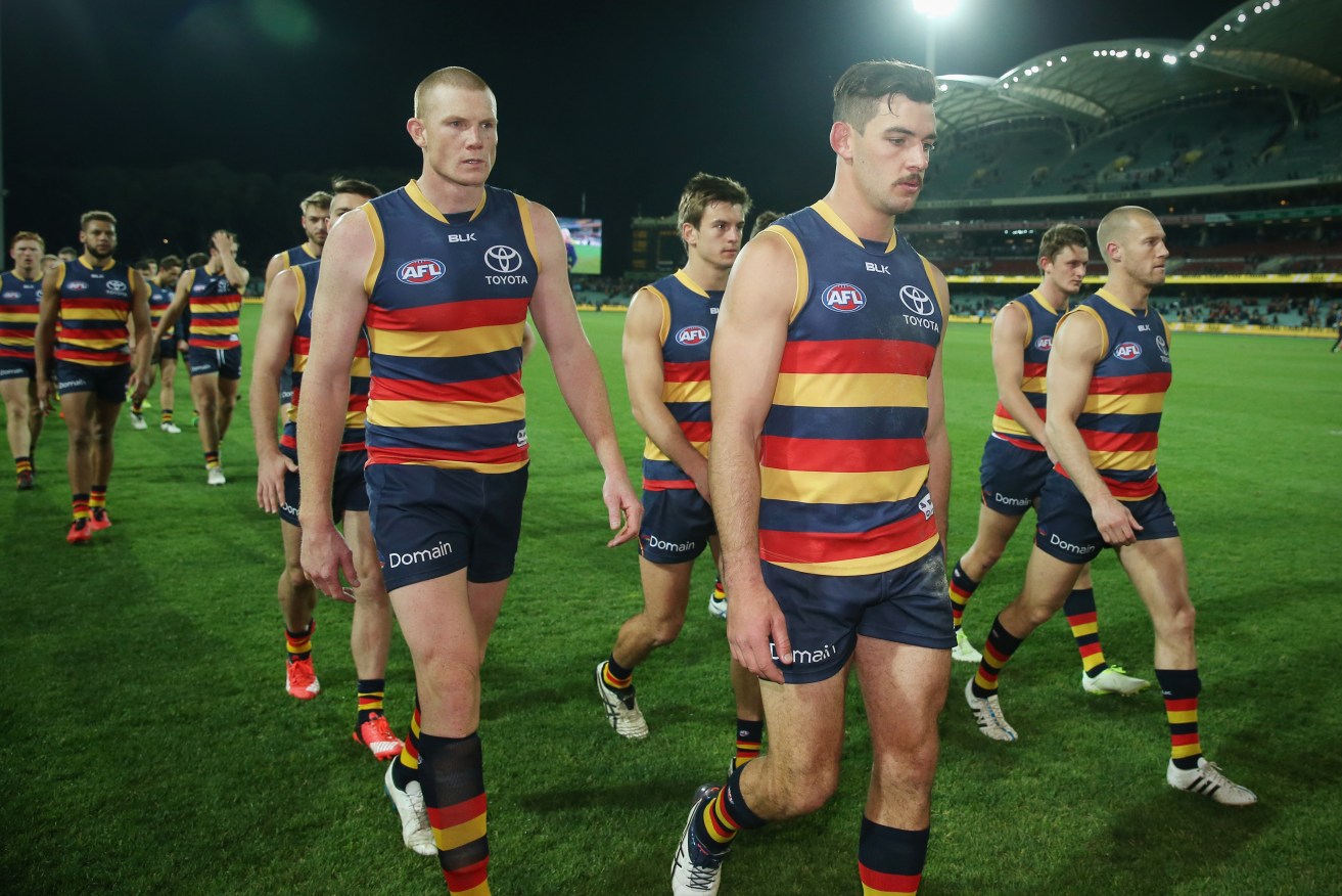 A despondent Taylor Walker leads his team from Adelaide Oval after the loss to the Eagles. Photo: Ben Macmahon / AAP