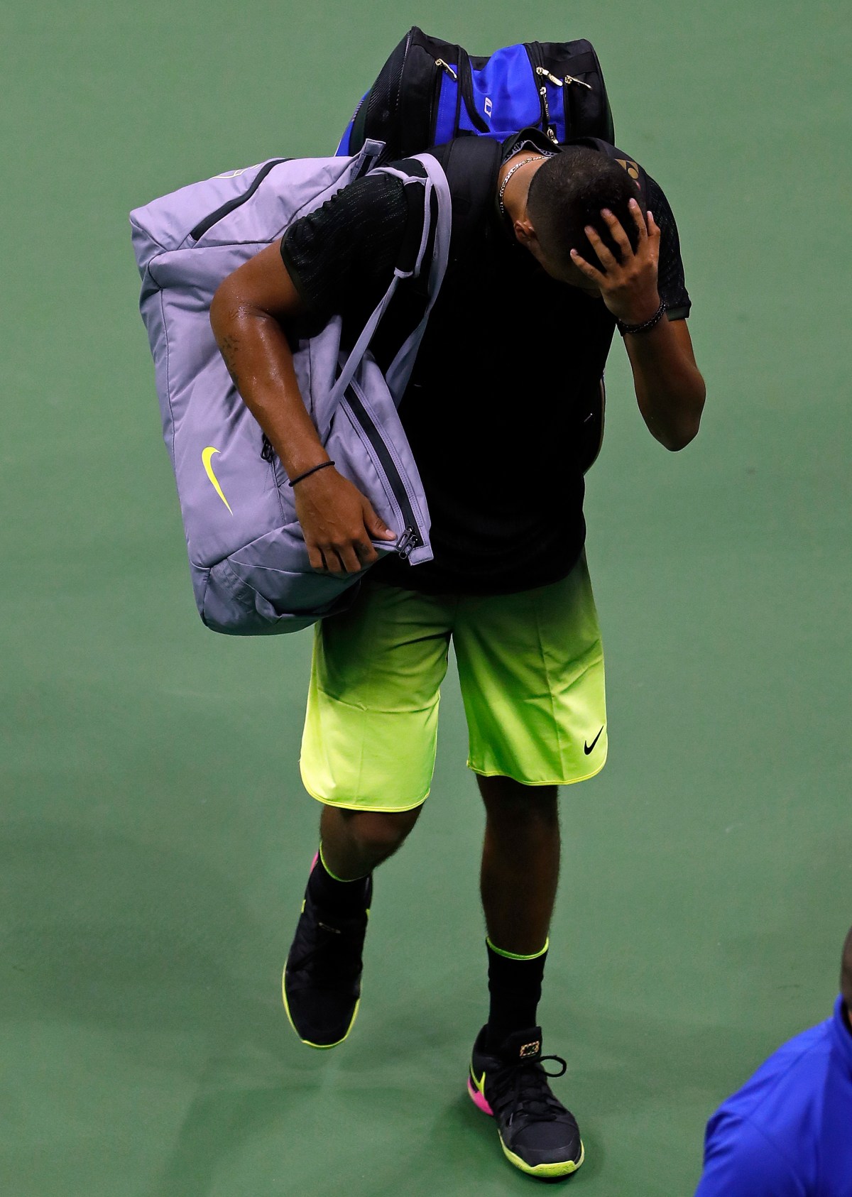 Nick Kyrgios limps off the court after retiring from a third round US Open match against Illya Marchenko. Photo: Adam Hunger / AAP