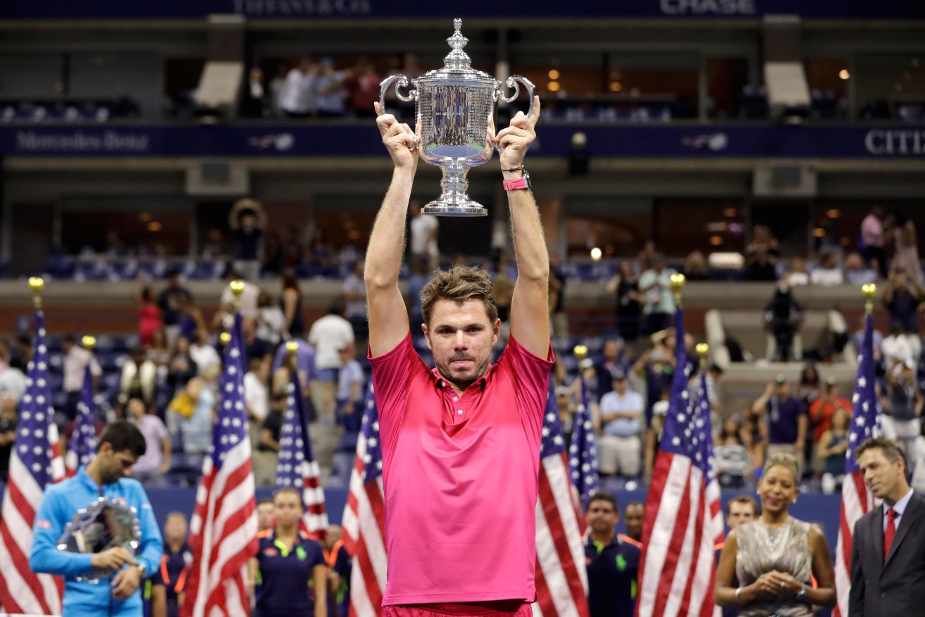 Stan Wawrinka holds up the championship trophy after beating Novak Djokovic to win the US Open men's singles final. Photo: Darron Cummings / AP
