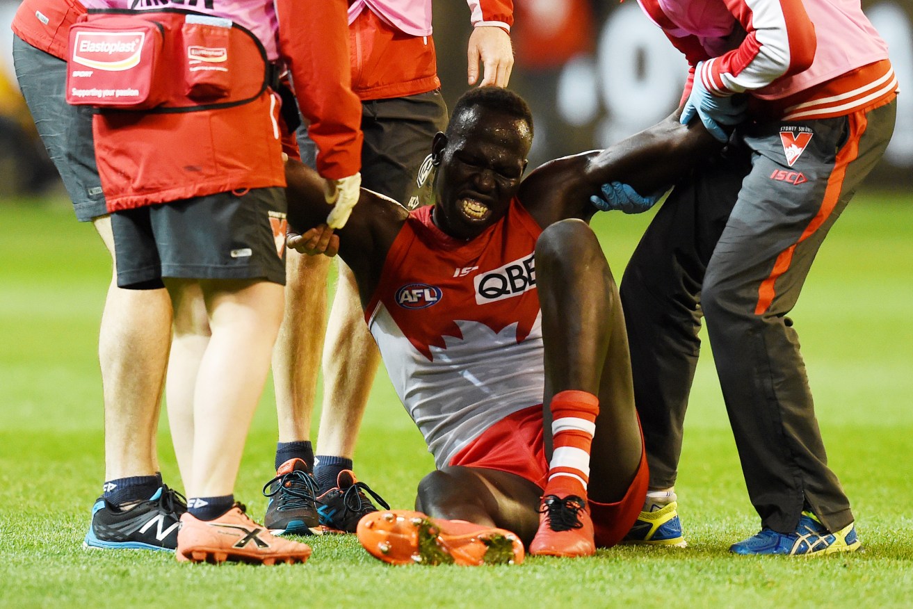 Aliir Aliir after injuring his knee on Friday night. Photo: Tracey Nearmy / AAP
