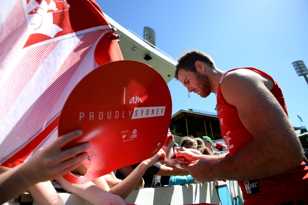 Sydney Swans player Ben McGlynn signs autographs for fans during an open training session and fan day, at the Sydney Cricket Ground, in Sydney, Monday, Sept. 26, 2016. The Sydney Swans will play the Western Bulldogs in the AFL Grand Final at the Melbourne Cricket Ground on Saturday. (AAP Image/Dan Himbrechts) NO ARCHIVING