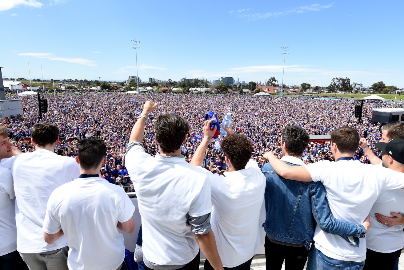 Western bulldogs players salute their fans at Whitten Oval after their historic Grand Final win. Photo: Tracey Nearmy / AAP