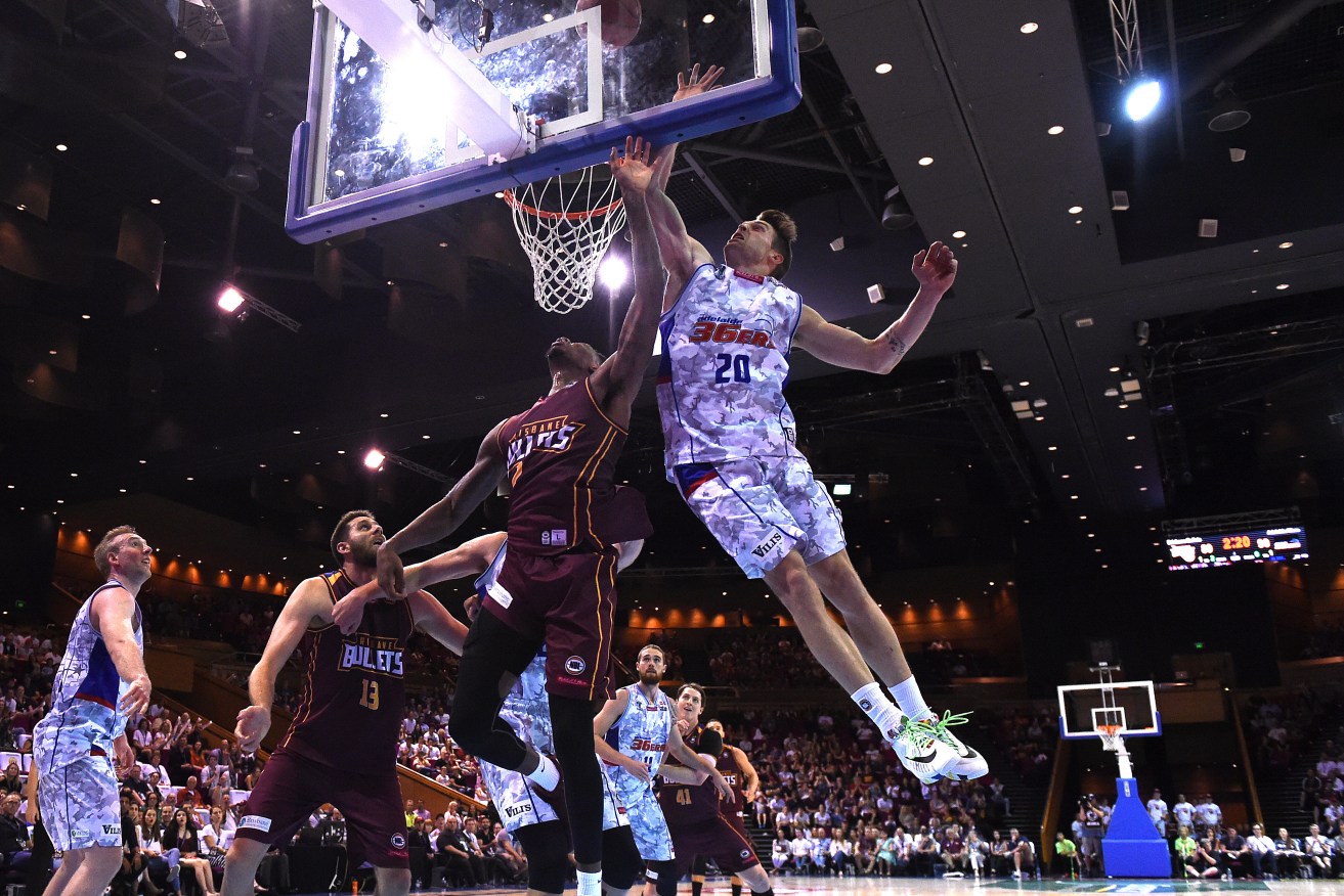 Nathan Sobey of the Adelaide 36ers (right) leaps for the basket against the Bullets in Brisbane. Photo: AAP/Dan Peled