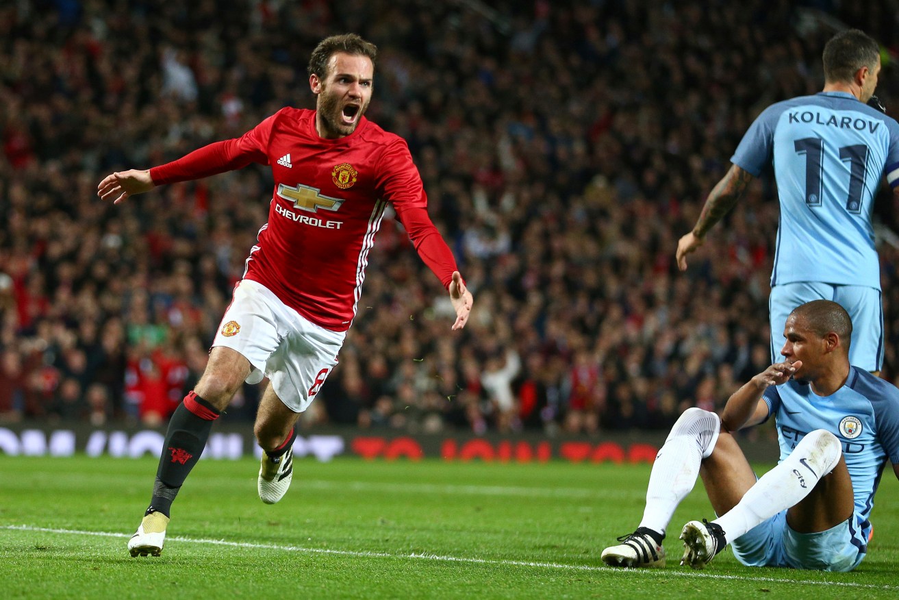 Manchester United's Juan Mata celebrates scoring a goal against crosstown rivals Manchester City at Old Trafford. Photo: Dave Thompson / AP