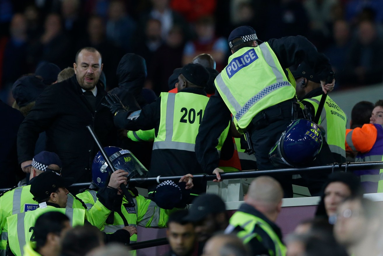 Police move into to separate rival supporters clashing with stewards during this week's English League Cup match between West Ham United and Chelsea. Photo: Alastair Grant / AP