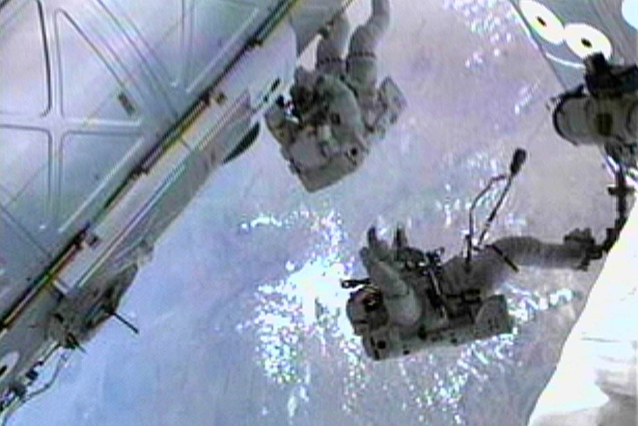 Astronauts Paul Richards (left) and South Australia's Andy Thomas work on the International Space Station in 2001. Photo: AP/NASA TV
