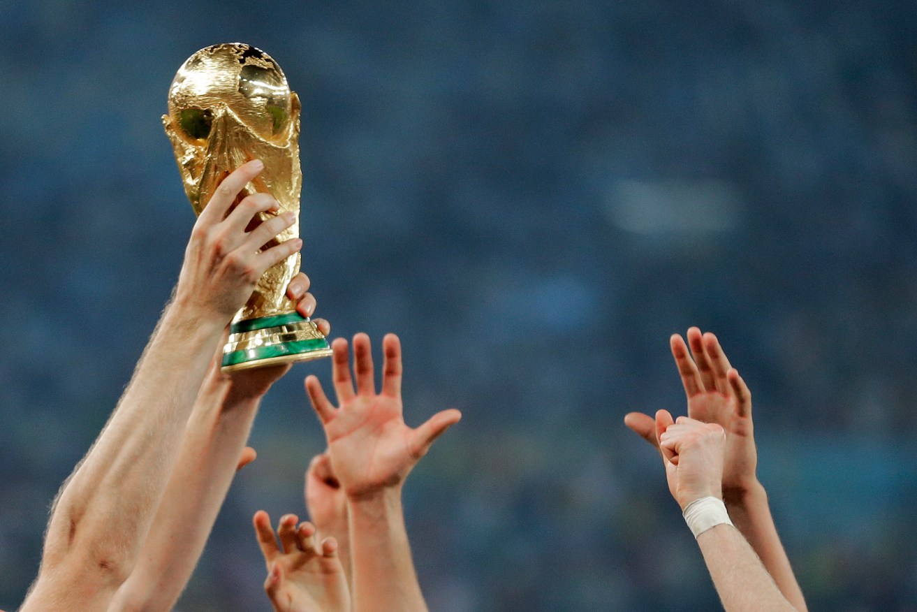 German players reach out to touch the trophy after the 2014 World Cup final. Photo: Matthias Schrader / AP