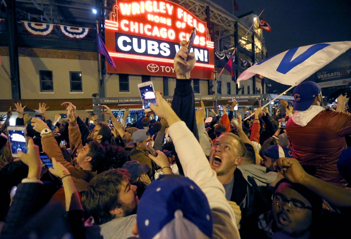Chicago Cubs fans celebrate in front of Wrigley Field in Chicago on Wednesday, Nov. 2, 2016, after the Cubs beat the Cleveland Indians 8-7 in Game 7 of the Major League World Series in Cleveland. (AP Photo/Charles Rex Arbogast)