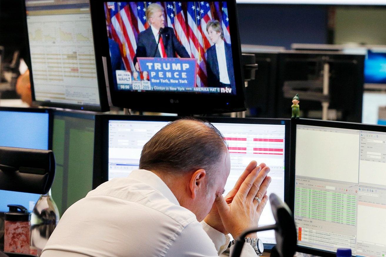A broker reacts as US President-elect Donald Trump shows up on a television screen at the stock market in Frankfurt, Germany. Photo: AP/Michael Probst)