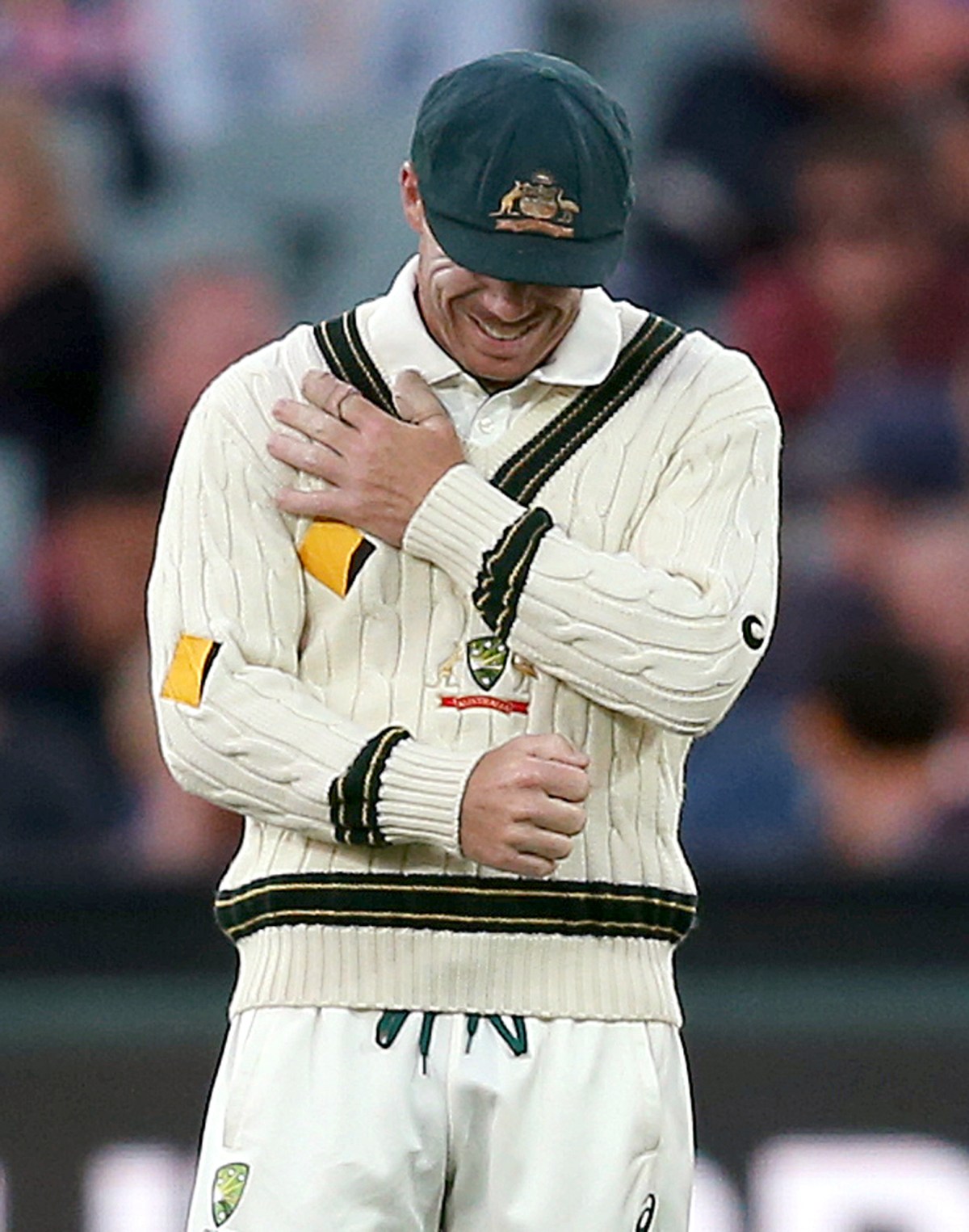 Australia's David Warner grabs at his arm while playing South Africa during their cricket test match in Adelaide, Australia, Thursday, Nov. 24, 2016. (AP Photo/Rick Rycroft)