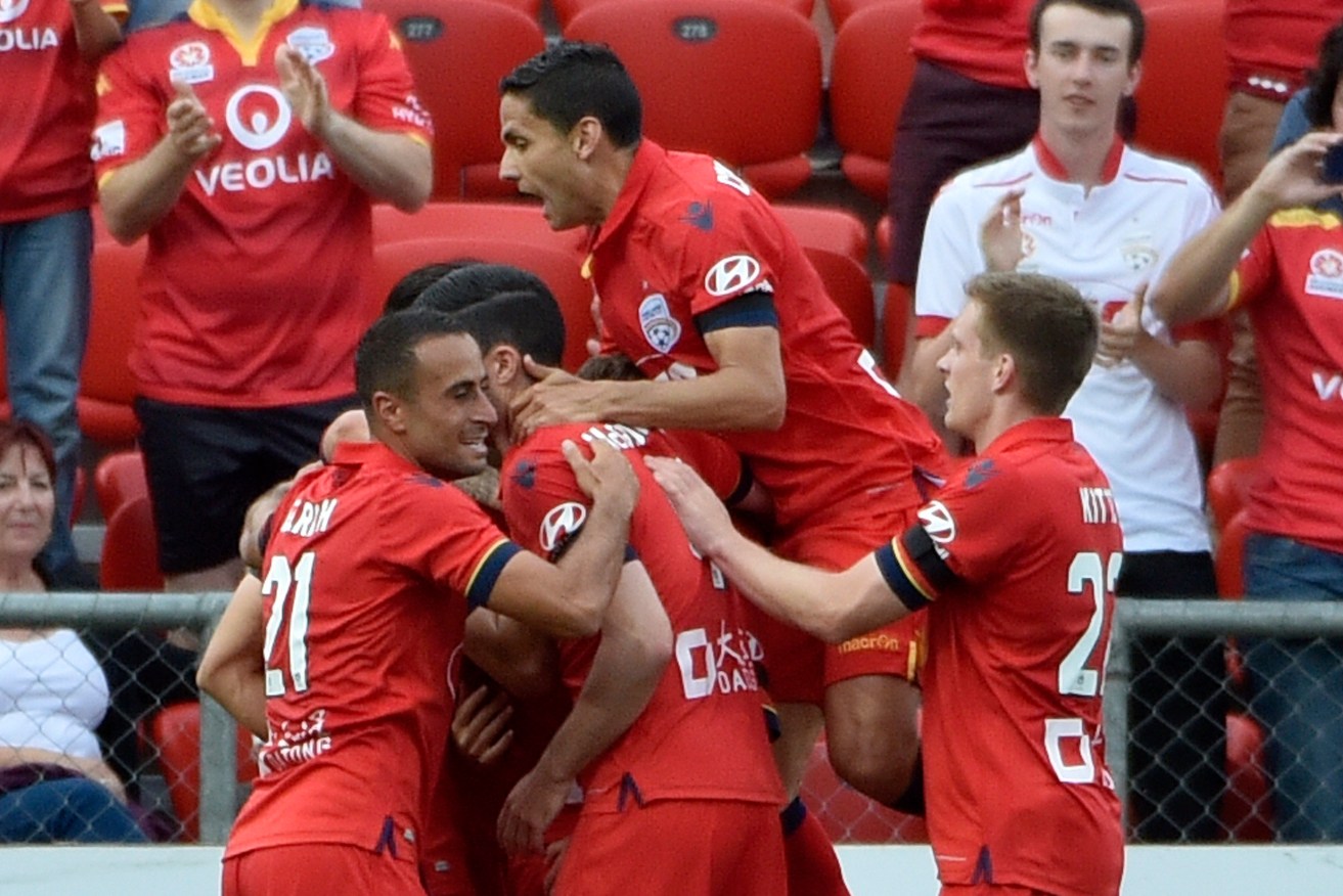 AT LONG LAST: United players celebrate a goal in their first win of the A-League season. Photo: David Mariuz / AAP