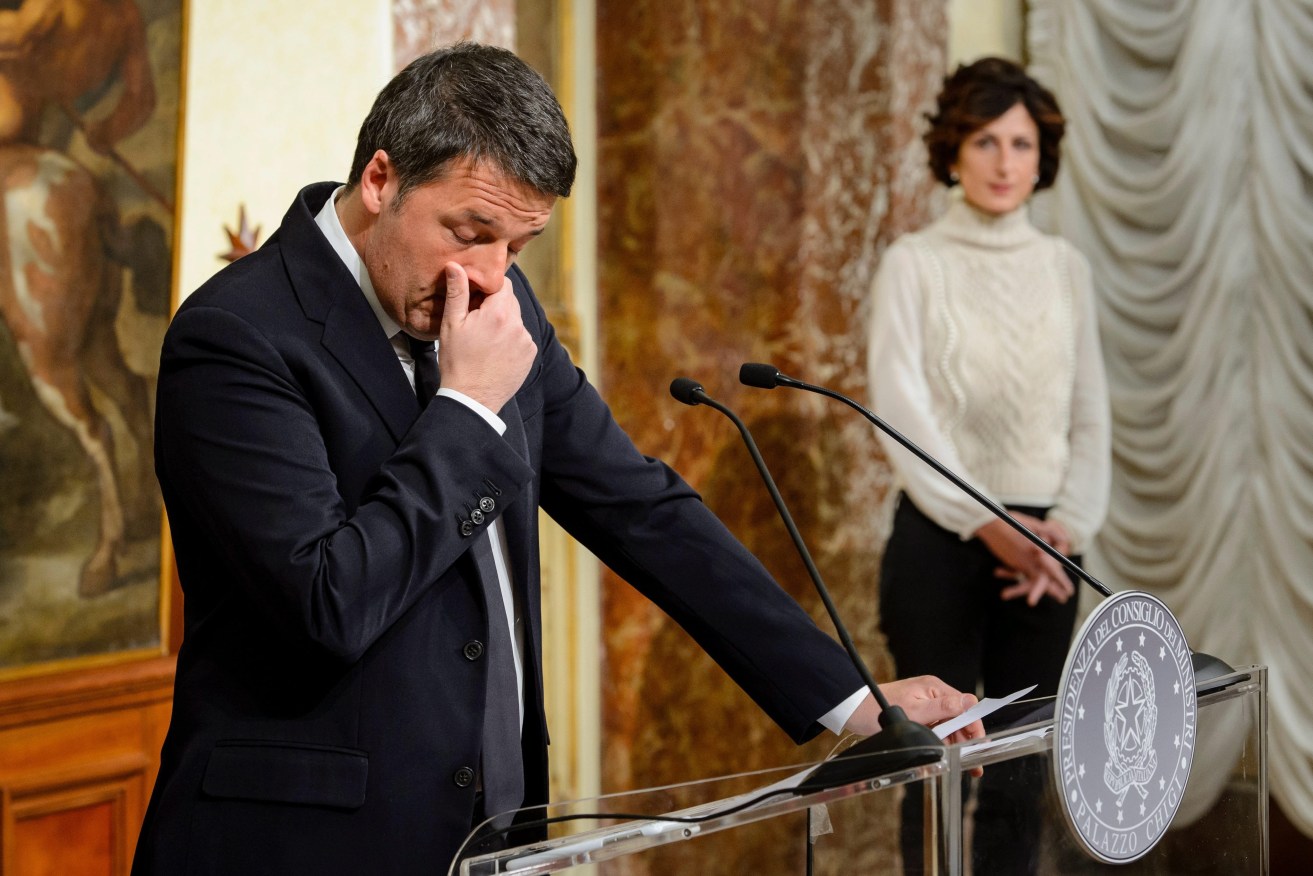 Italian Prime Minister Matteo Renzi speaks at the Palazzo Chigi in Rome, after the referendum on constitutional reform, with his wife Agnese Landini in the background. Photo: EPA/Gregor Fischer